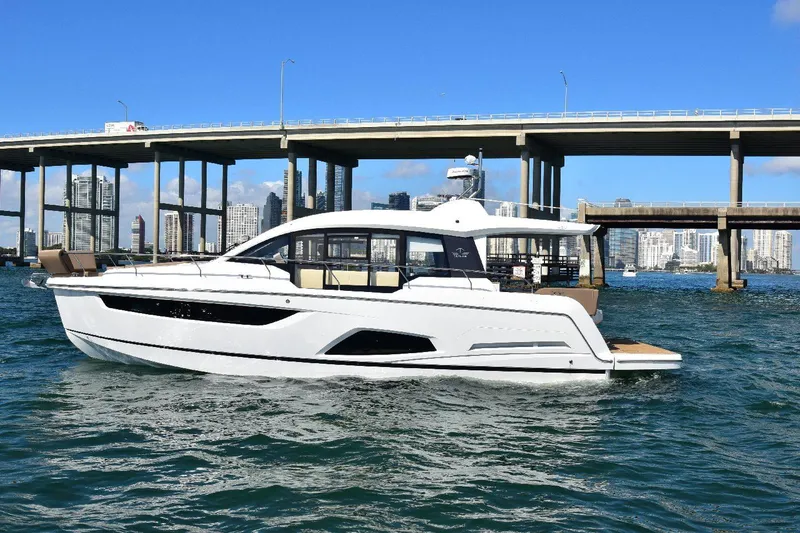 Slide: The Image of 2022 Sealine C430 #42 yacht cruising under a bridge in a cityscape setting. - 18