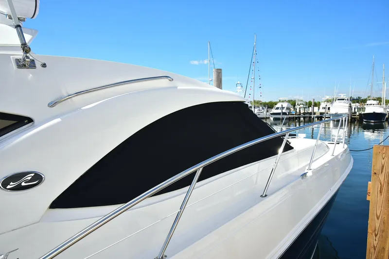 Slide: The Image of 2013 Sea Ray 410 Sundancer yacht docked at marina, sleek design, sunny day. - 15