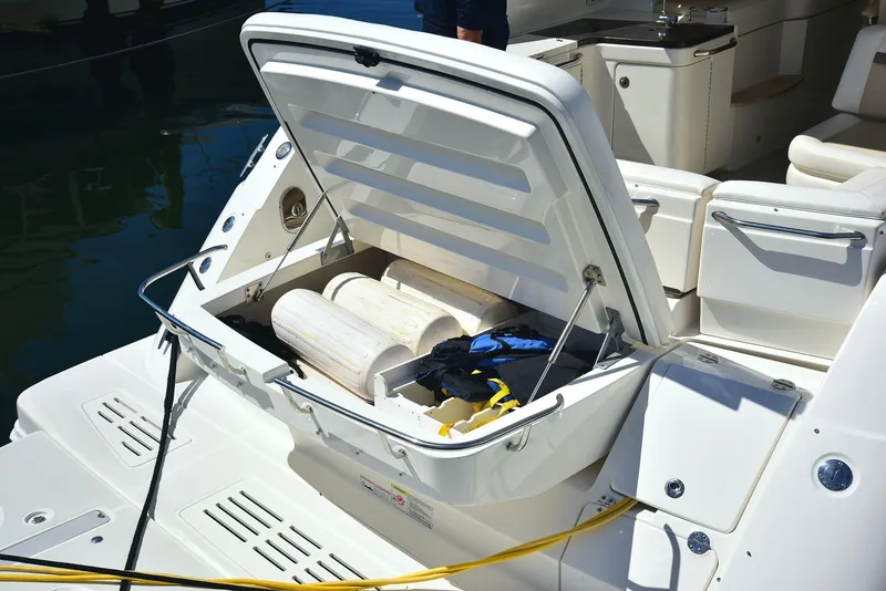 Slide: The Image of 2013 Sea Ray 410 Sundancer boat with open storage compartment, docked at marina. - 22