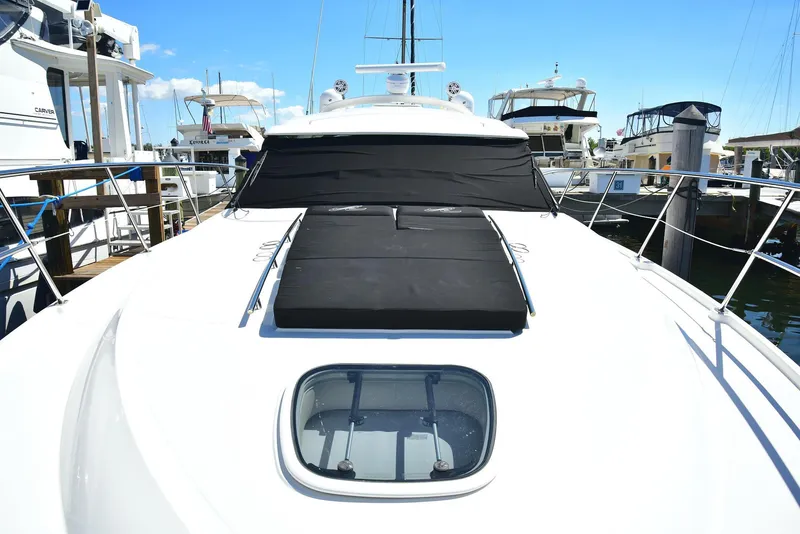Slide: The Image of 2013 Sea Ray 410 Sundancer yacht docked at marina, featuring sleek design and sunpad. - 27