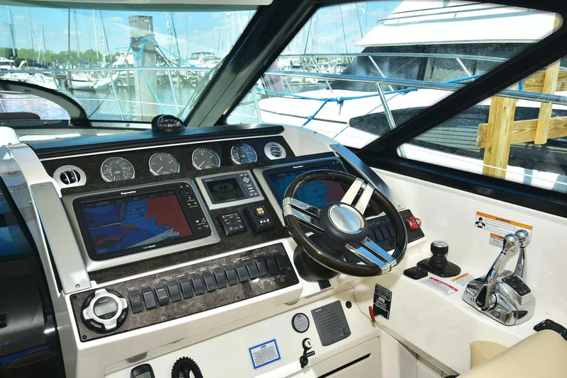 Slide: The Image of Helm of 2013 Sea Ray 410 Sundancer with navigation controls and steering wheel. - 44