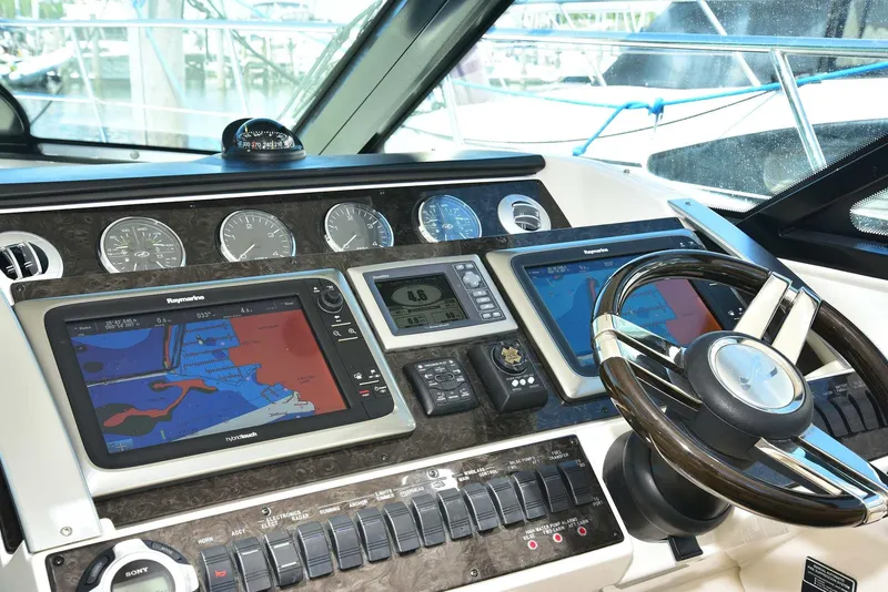 Slide: The Image of Cockpit of 2013 Sea Ray 410 Sundancer with navigation displays and steering wheel. - 45