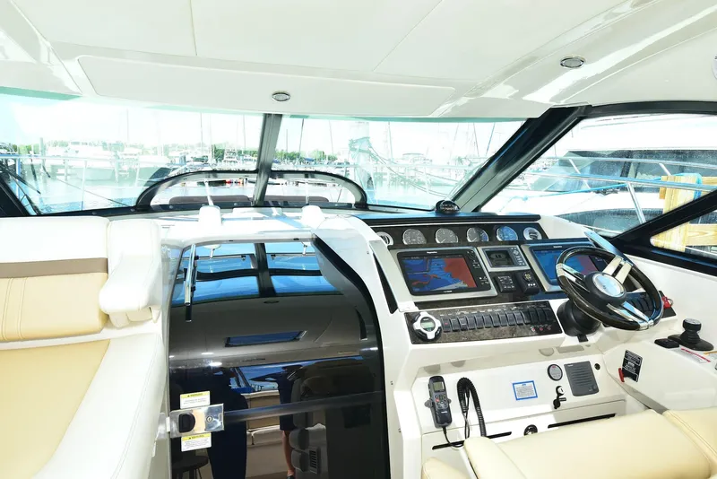 Slide: The Image of Cockpit of 2013 Sea Ray 410 Sundancer with modern navigation controls and steering wheel. - 46