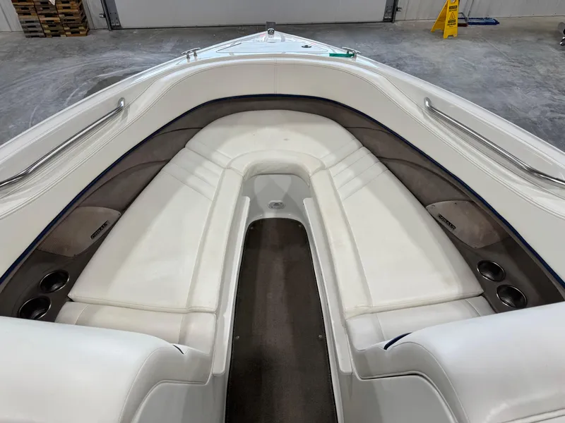 Slide: The Image of 2004 Cobalt 262 BR boat interior with white cushioned seating and cup holders. - 10
