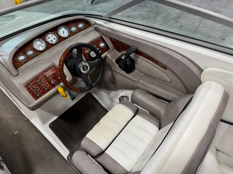 Slide: The Image of 2004 Cobalt 262 BR boat interior with wood-accented dashboard and steering wheel. - 9