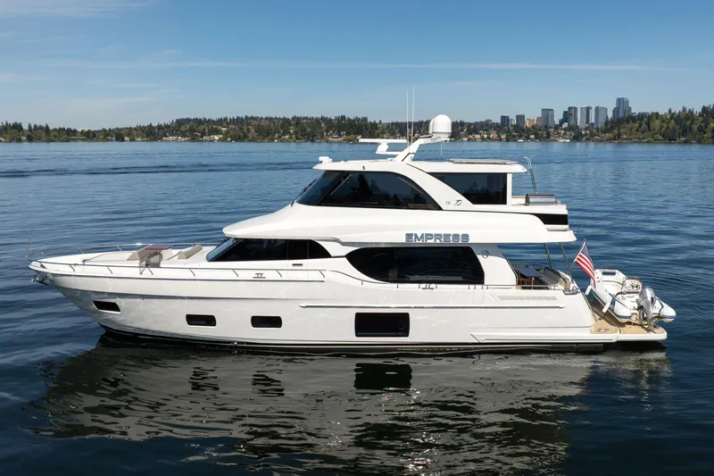 Slide: The Image of 2018 Ocean Alexander 70E Motoryacht on calm water, city skyline in background. - 0