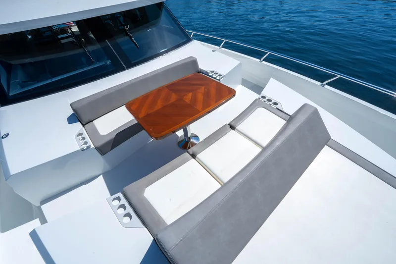 Slide: The Image of 2018 Ocean Alexander 70E Motoryacht deck with seating and table, overlooking blue water. - 11