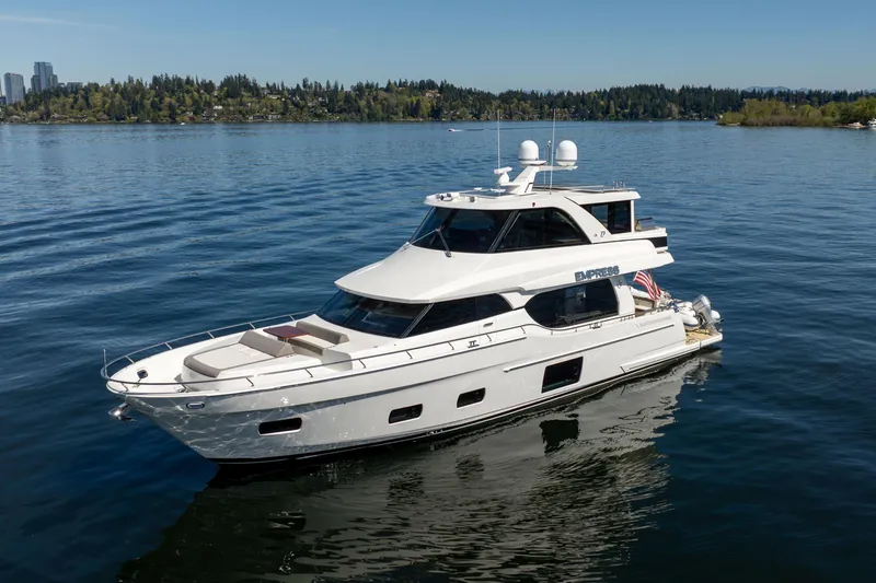 Slide: The Image of 2018 Ocean Alexander 70E Motoryacht cruising on a serene lake with forested shoreline. - 2