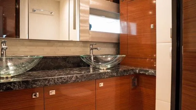 Slide: The Image of Luxurious bathroom in 2018 Ocean Alexander 70E Motoryacht with dual glass sinks and wood cabinetry. - 40