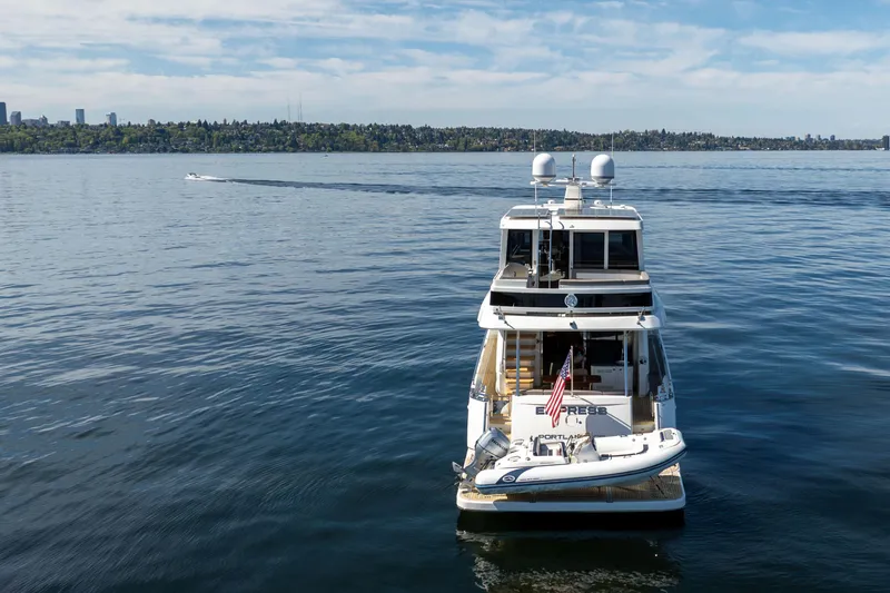 Slide: The Image of 2018 Ocean Alexander 70E Motoryacht on calm water, city skyline in background. - 5