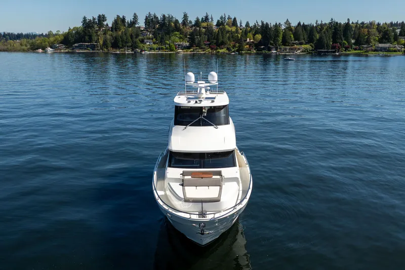 Slide: The Image of 2018 Ocean Alexander 70E Motoryacht on serene water with forested shoreline. - 6