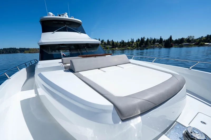Slide: The Image of 2018 Ocean Alexander 70E Motoryacht on serene water, featuring sleek design and spacious deck. - 9