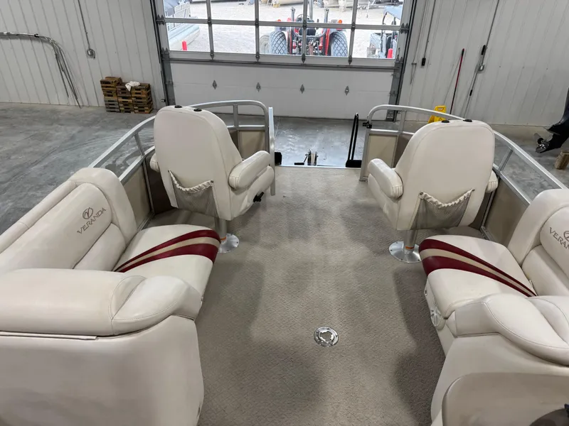 Slide: The Image of 2007 Veranda VP 22 boat interior with white seating and red accents in a garage. - 11