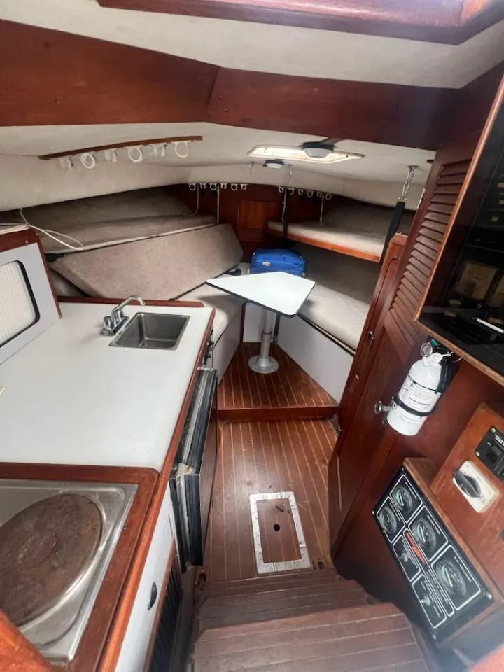 Slide: The Image of 1988 Black Watch 30 Sportfish Convertible cabin with kitchenette, seating, and wood accents. - 11