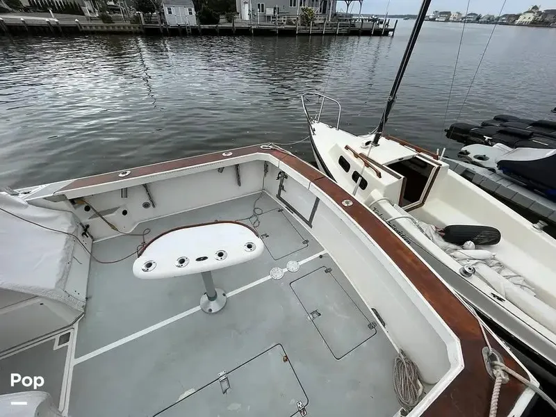 Slide: The Image of 1988 Black Watch 30 Sportfish Convertible boat docked, featuring spacious deck and fishing rod holders. - 5