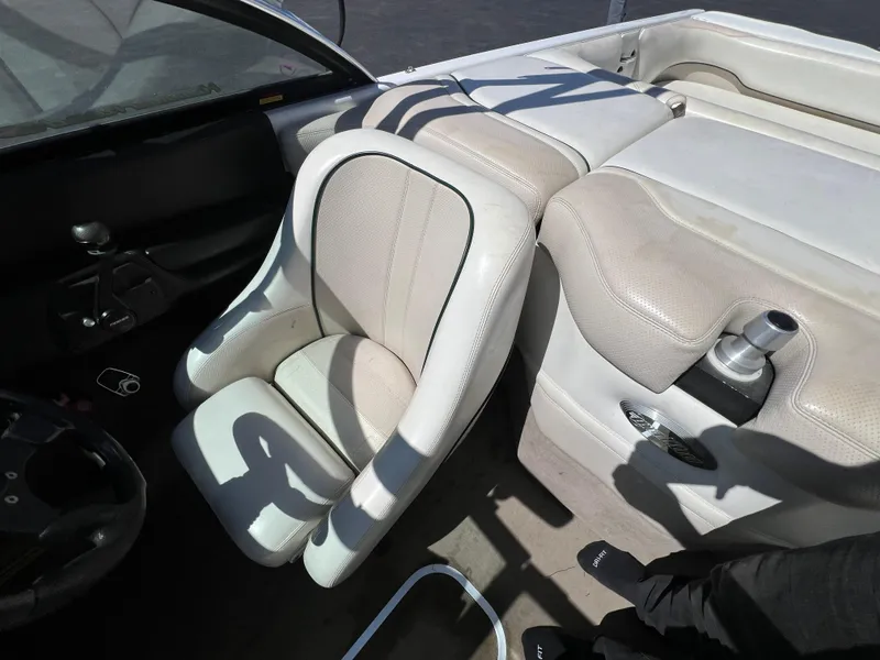 Slide: The Image of 2003 Malibu 23 XTi boat interior with white seating and steering wheel. - 15