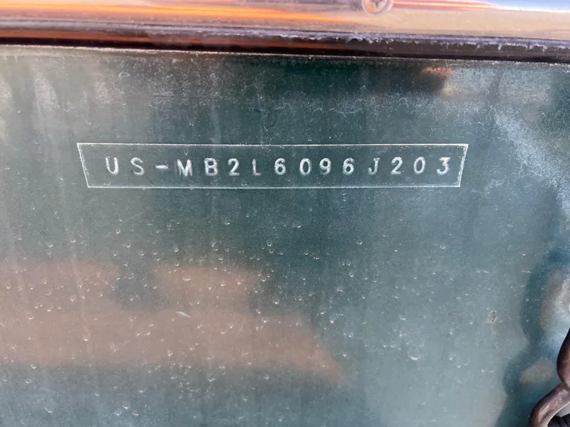 Slide: The Image of VIN on 2003 Malibu 23 XTi boat, US-MB2L6096J203, displayed on a green surface. - 19