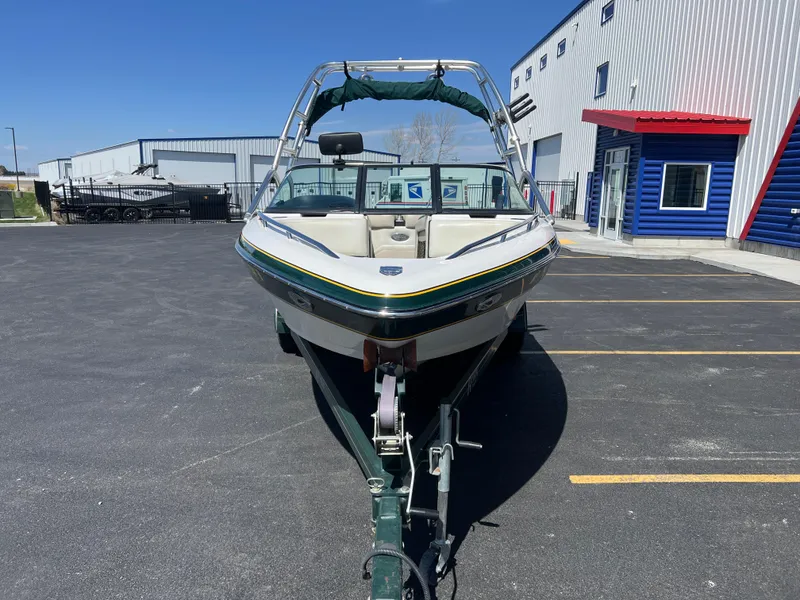 Slide: The Image of 2003 Malibu 23 XTi boat on trailer in parking lot, near industrial buildings. - 4