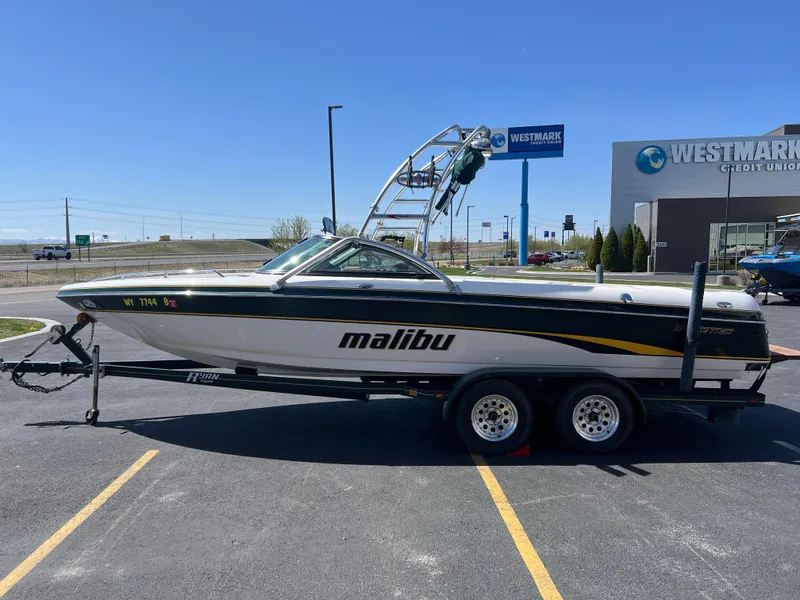 Slide: The Image of 2003 Malibu 23 XTi boat on trailer in parking lot near Westmark Credit Union. - 6