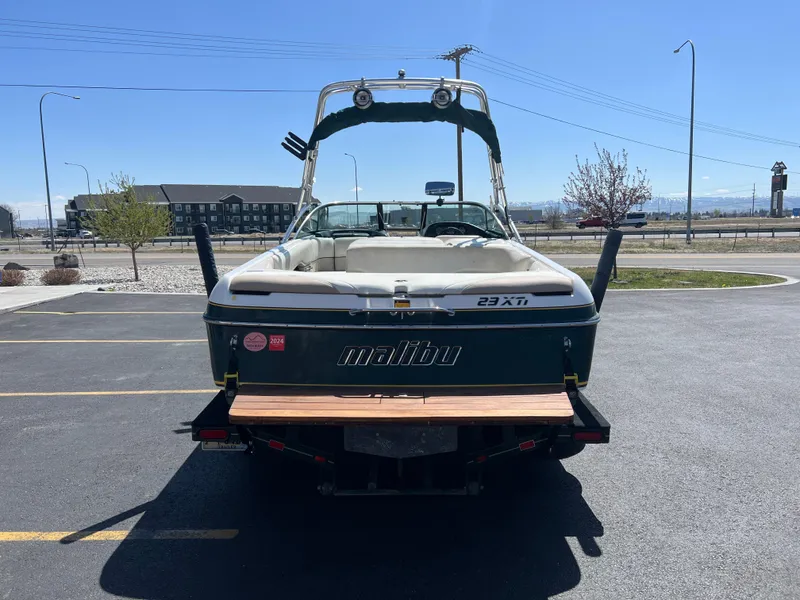 Slide: The Image of 2003 Malibu 23 XTi boat parked in a lot under clear blue sky. - 8