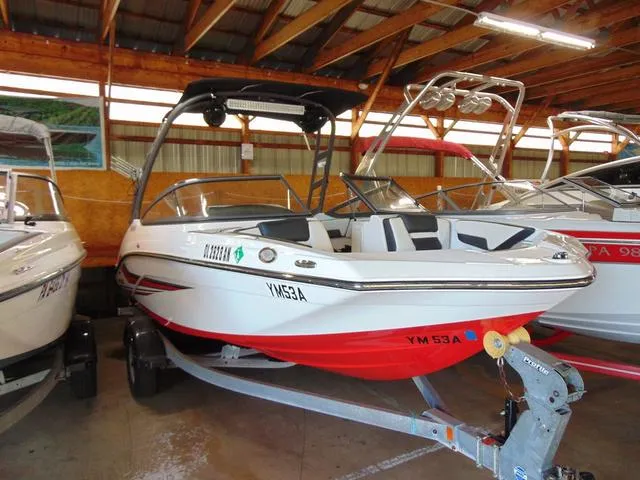Slide: The Image of 2020 Yamaha Boats AR195 in storage, featuring a sleek design and vibrant red hull. - 1
