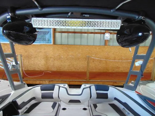 Slide: The Image of 2020 Yamaha Boats AR195 interior with seating and overhead speakers in a showroom. - 10