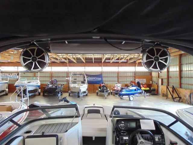 Slide: The Image of 2020 Yamaha AR195 boat interior with speakers, in a showroom with various watercraft. - 12