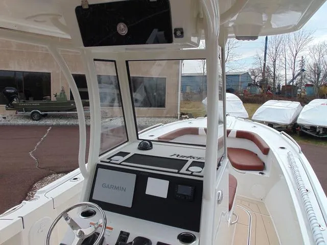 Slide: The Image of 2025 Parker 2400 Center Console boat with Garmin navigation system, docked outdoors. - 12