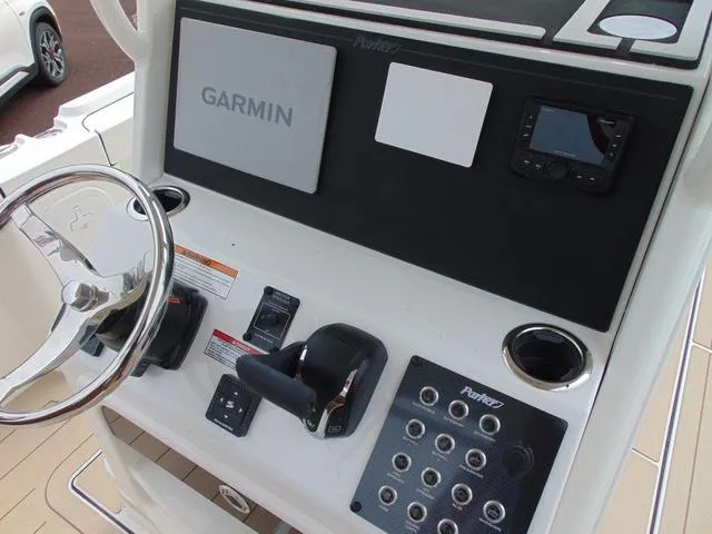 Slide: The Image of 2025 Parker 2400 Center Console boat dashboard with Garmin navigation system and steering wheel. - 13
