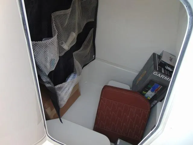 Slide: The Image of Storage compartment in 2025 Parker 2400 Center Console boat with netting and Garmin box. - 24
