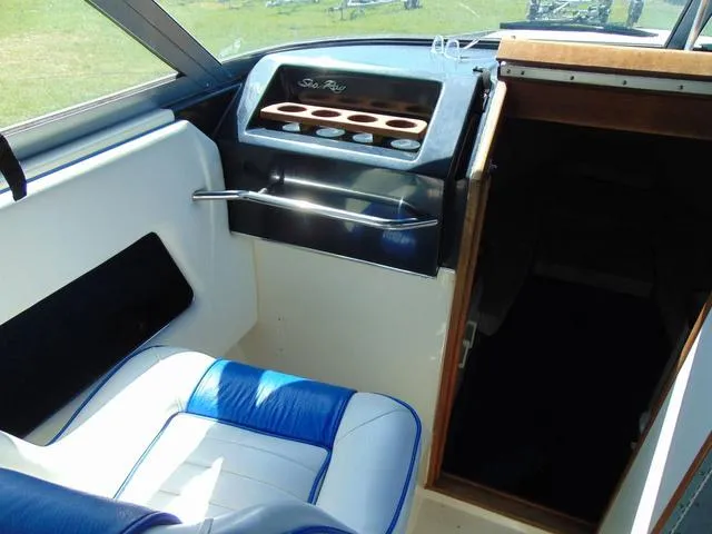 Slide: The Image of 1990 Sea Ray 260 Overnighter interior with blue and white seating and dashboard. - 11