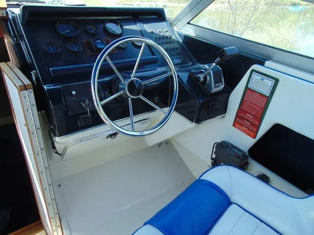 Slide: The Image of 1990 Sea Ray 260 Overnighter boat cockpit with steering wheel and control panel. - 12