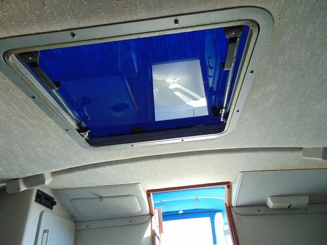 Slide: The Image of Interior view of 1990 Sea Ray 260 Overnighter boat with blue hatch window. - 21