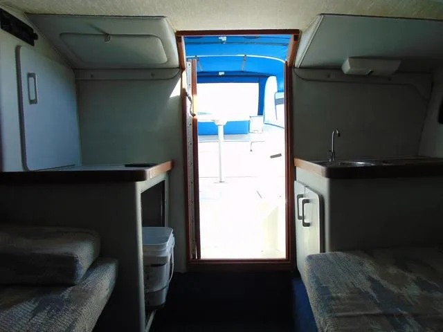 Slide: The Image of Interior view of 1990 Sea Ray 260 Overnighter boat cabin with seating and kitchenette. - 22