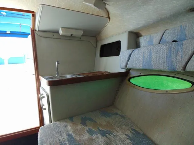 Slide: The Image of Interior of 1990 Sea Ray 260 Overnighter boat with kitchenette and seating area. - 24