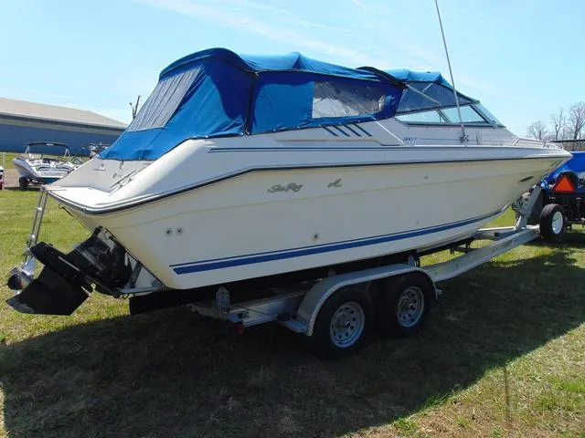 Slide: The Image of 1990 Sea Ray 260 Overnighter boat on trailer with blue canopy, parked on grass. - 5