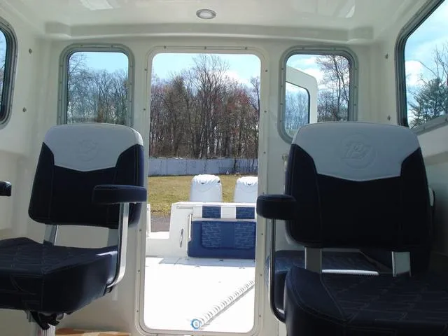 Slide: The Image of Interior view of 2025 Parker 2420 Sport Cabin boat with two black seats. - 13