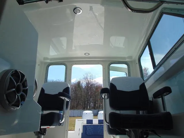 Slide: The Image of Interior of 2025 Parker 2420 Sport Cabin boat with two seats and large windows. - 14