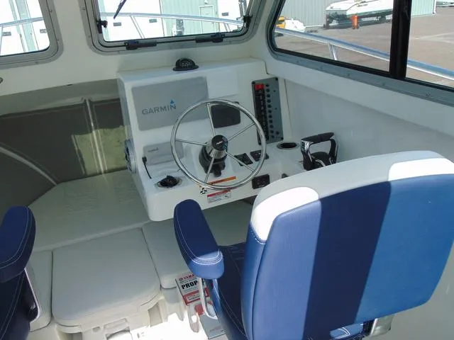 Slide: The Image of 2025 Parker 2420 Sport Cabin interior with steering wheel and Garmin navigation system. - 18