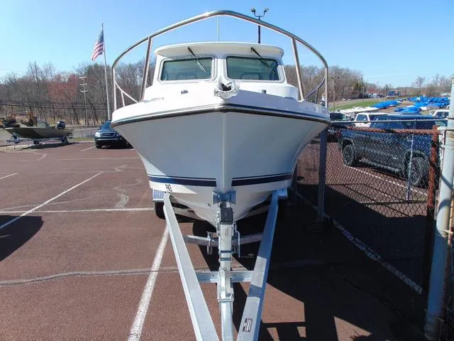 Slide: The Image of 2025 Parker 2420 Sport Cabin boat on trailer in parking lot. - 3