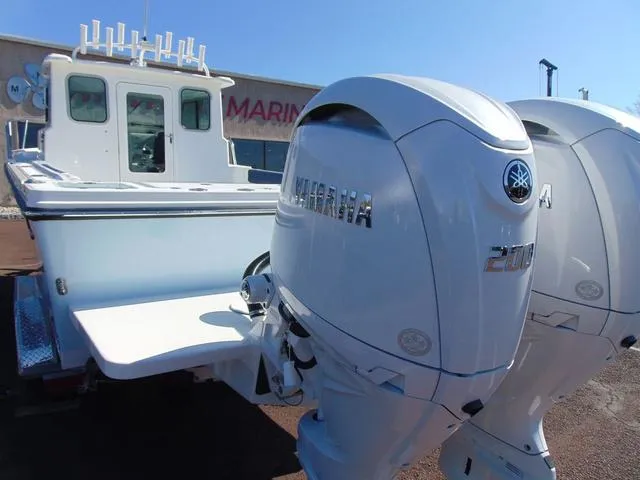 Slide: The Image of 2025 Parker 2420 Sport Cabin boat with dual Yamaha outboard engines. - 4