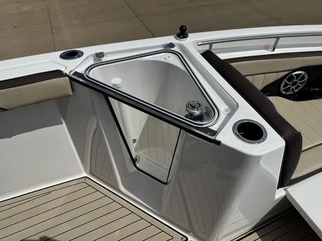 Slide: The Image of 2022 Yamaha Boats 255 FSH® SPORT E bow storage compartment with cup holders and seating. - 16