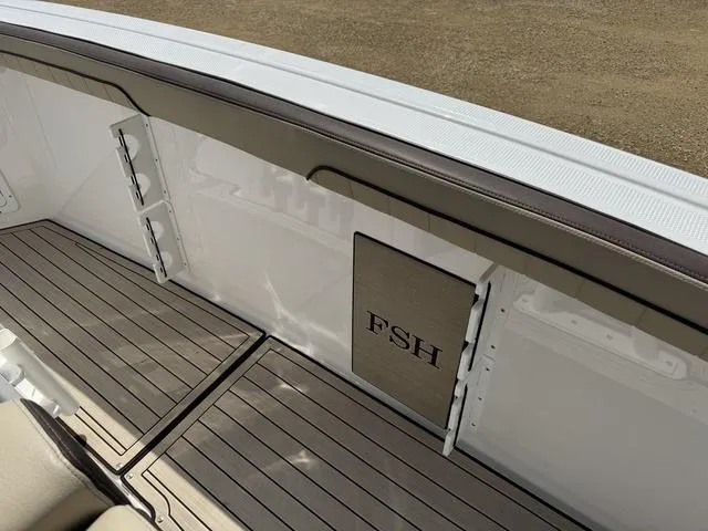 Slide: The Image of 2022 Yamaha Boats 255 FSH® SPORT E interior with sleek deck and FSH branding. - 18