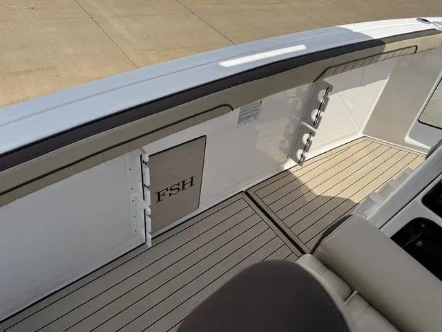 Slide: The Image of 2022 Yamaha Boats 255 FSH® SPORT E interior with sleek deck and storage compartment. - 19