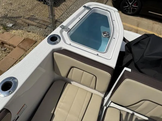 Slide: The Image of 2022 Yamaha Boats 255 FSH® SPORT E interior with seating and storage compartment. - 20