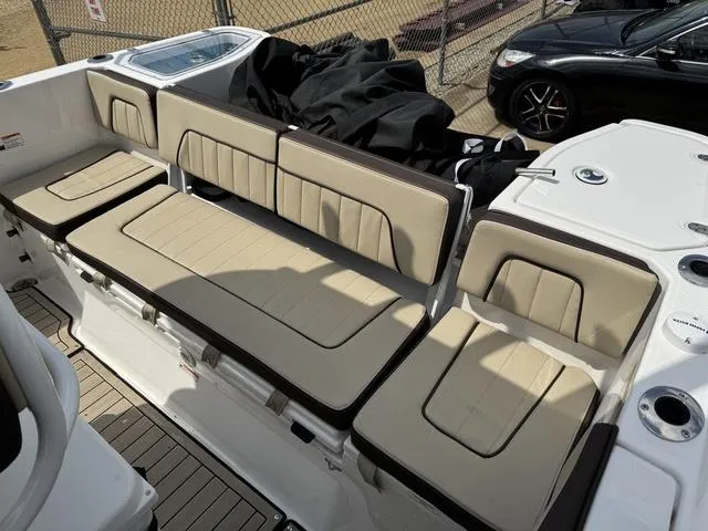 Slide: The Image of 2022 Yamaha Boats 255 FSH® SPORT E interior seating, beige cushions, outdoor setting. - 6