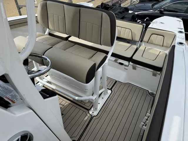 Slide: The Image of 2022 Yamaha Boats 255 FSH® SPORT E interior with beige seating and sleek design. - 7