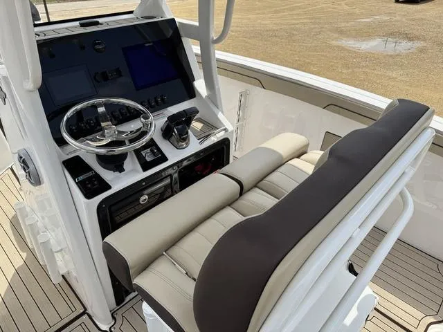 Slide: The Image of 2022 Yamaha Boats 255 FSH® SPORT E helm with dual screens and cushioned seating. - 9