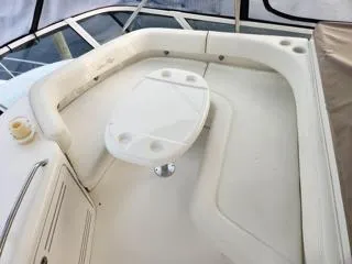Slide: The Image of 2004 Sea Ray 480 Sedan Bridge yacht seating area with table and cup holders. - 10