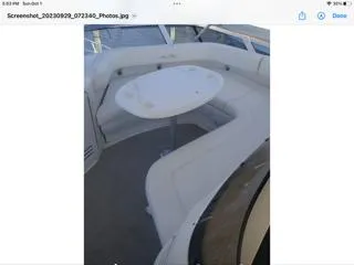 Slide: The Image of 2004 Sea Ray 480 Sedan Bridge yacht with white seating and round table on deck. - 11